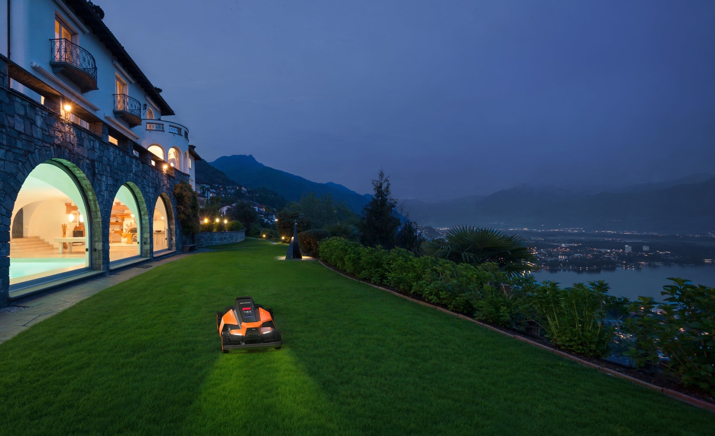 Navimow i110E robot lawn mower mows green grass at night.