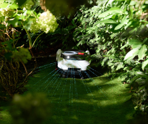 Navimow i110N robot lawn mower in a lush green garden.