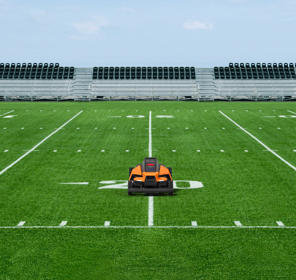 Navimow i110N robot lawn mower on a green football field.