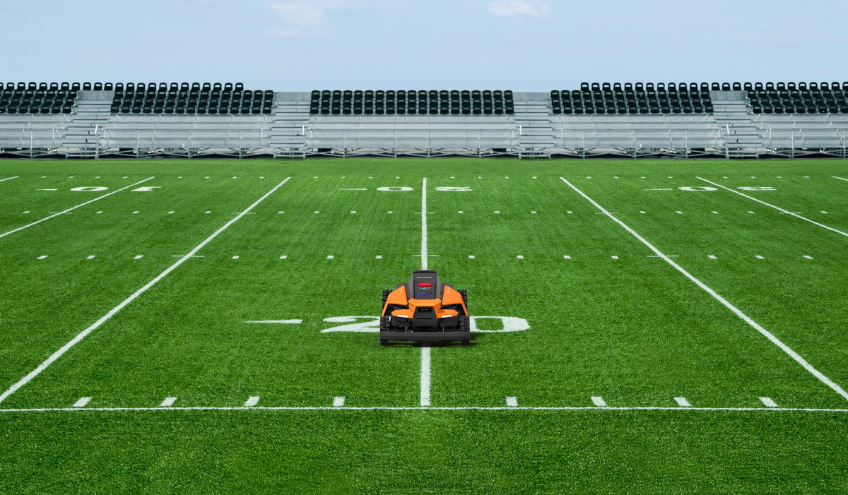 Navimow i110N robot lawn mower on the green football field.