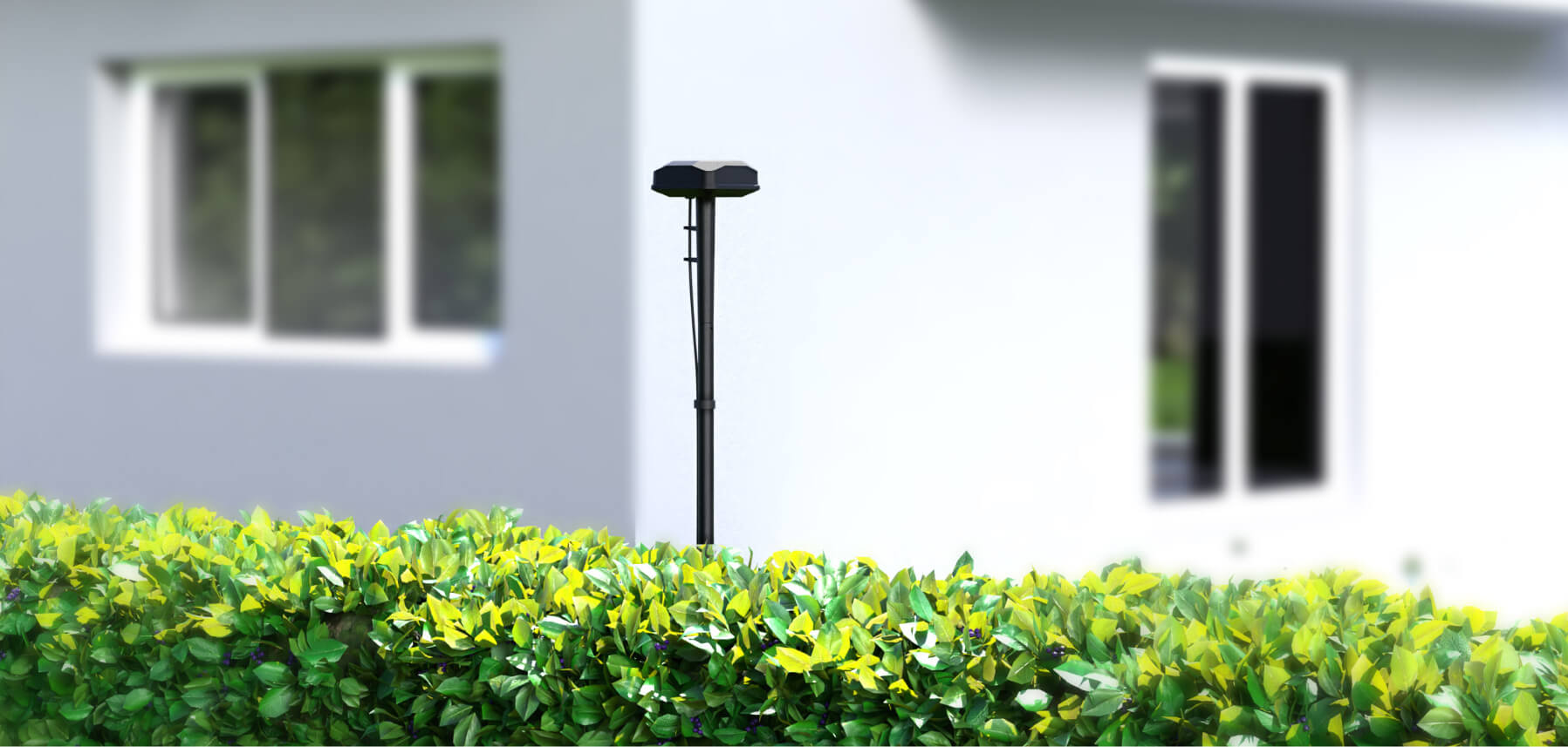 Navimow i110E robot lawn mower antenna stands behind a hedge.
