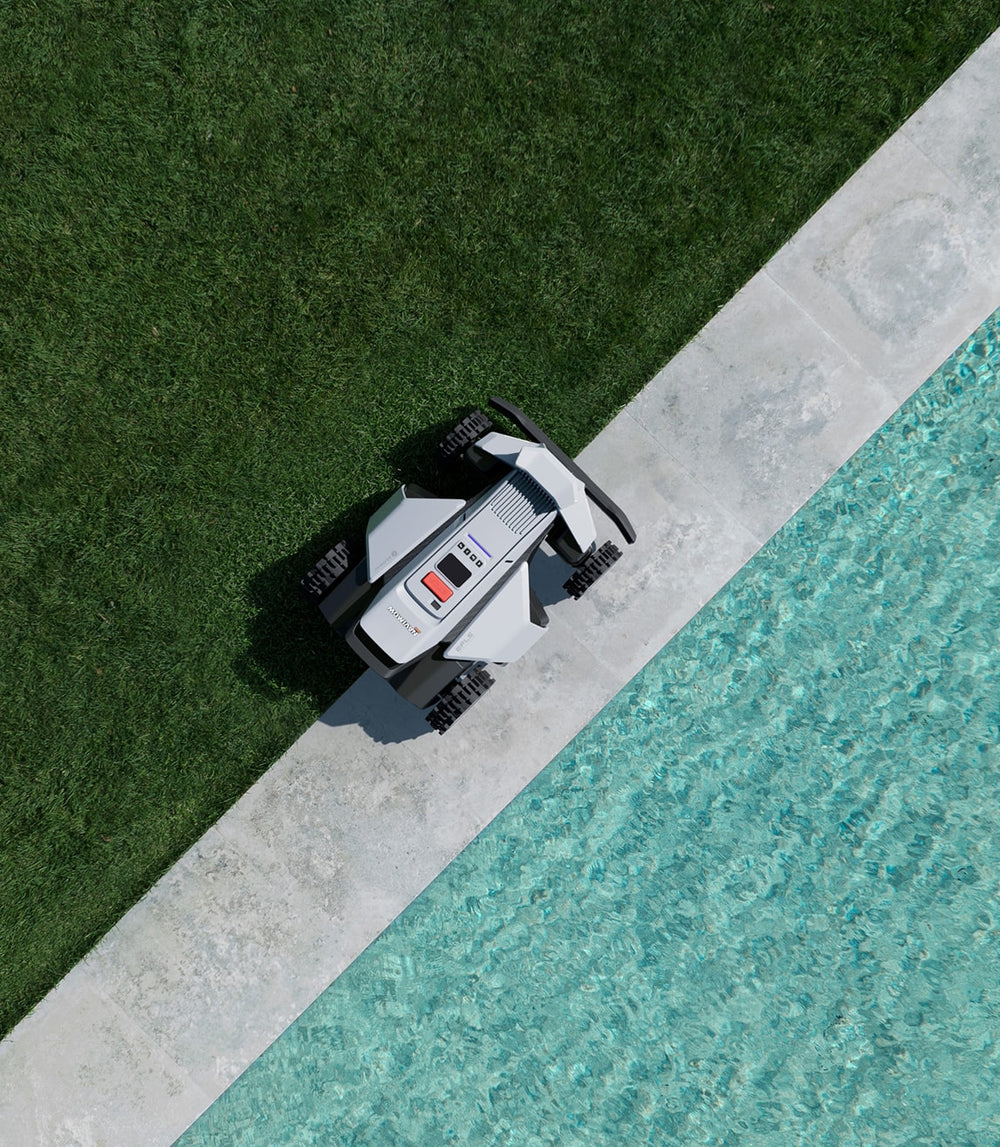 Navimow i105 robot lawn mower sits on a stone patio.