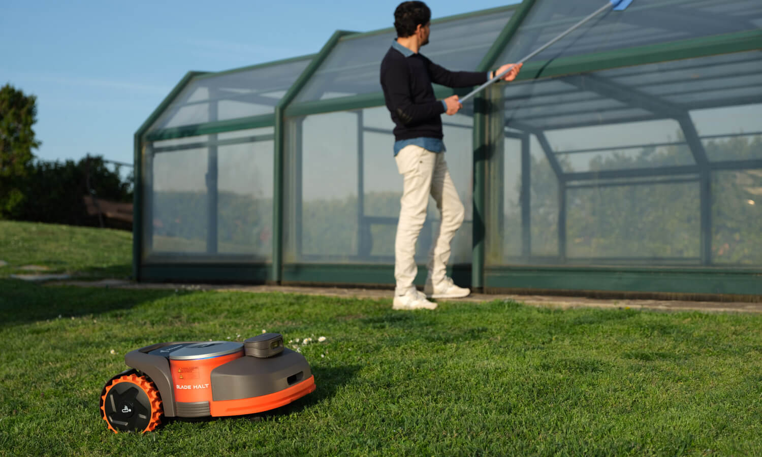 Navimow i110E robot lawn mower sits on the green grass.