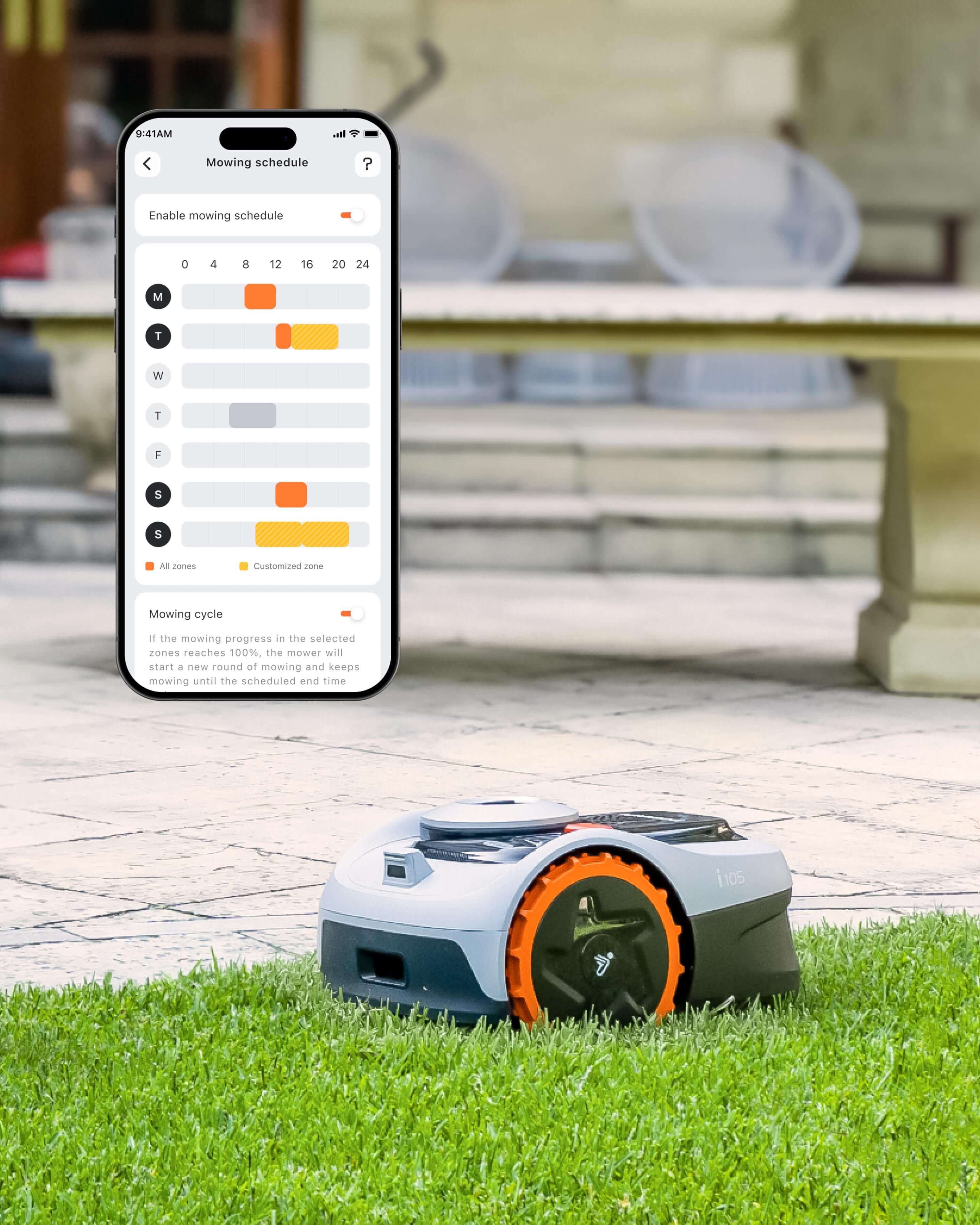 Navimow i105 robot lawn mower on grass beside a phone.