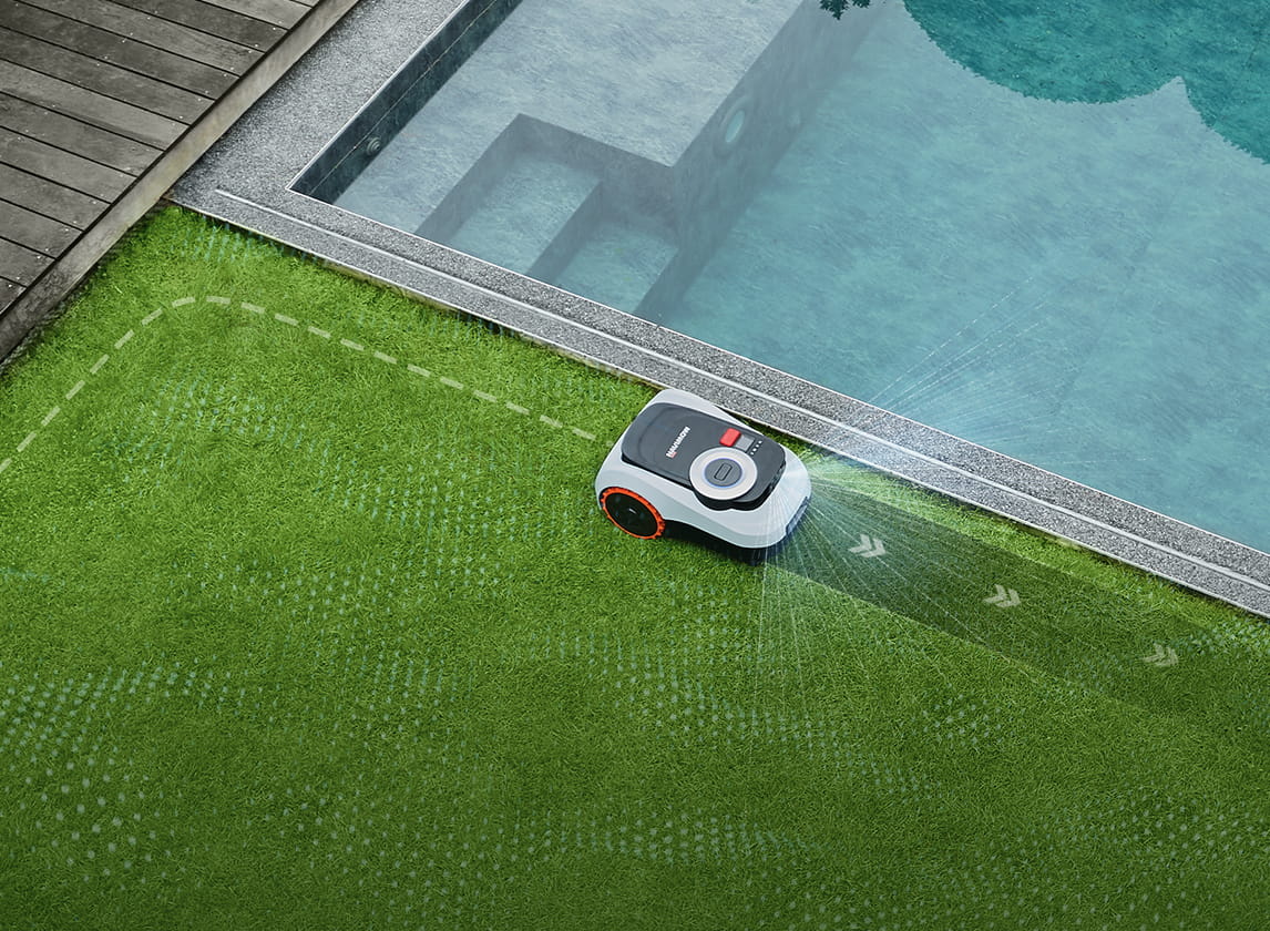 Navimow i105E robot lawn mower mows the grass near pool.