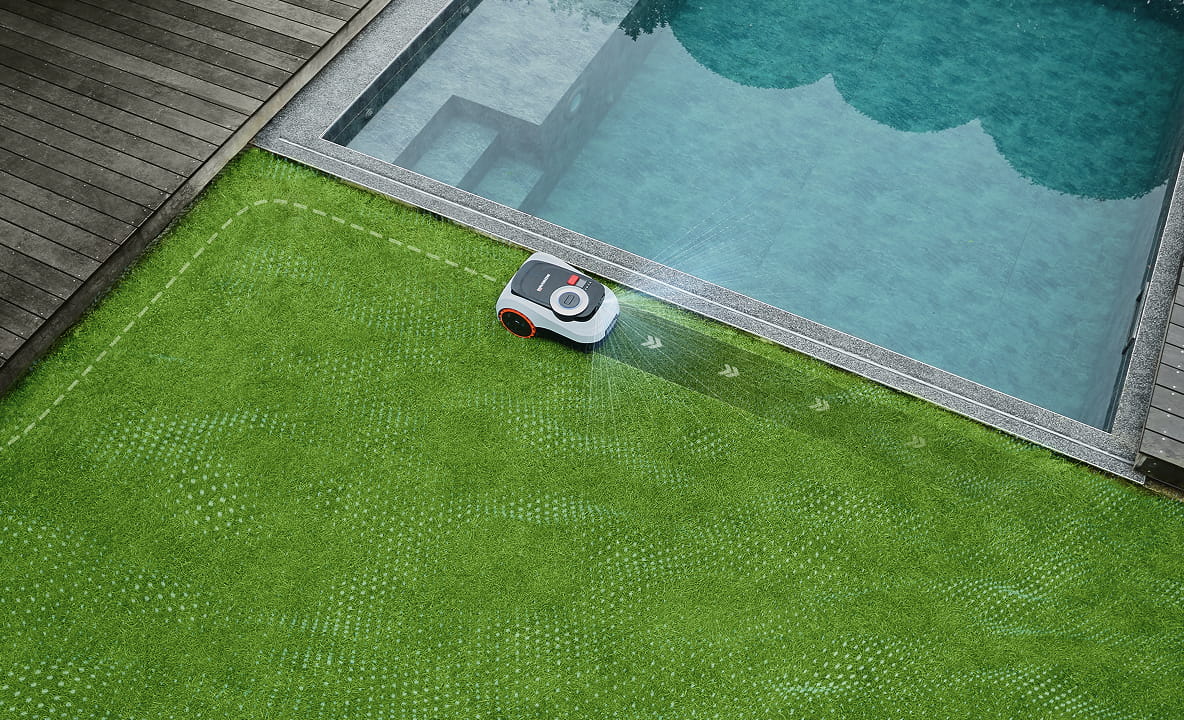 Segway Navimow i105E robot lawn mower mows lawn near pool.
