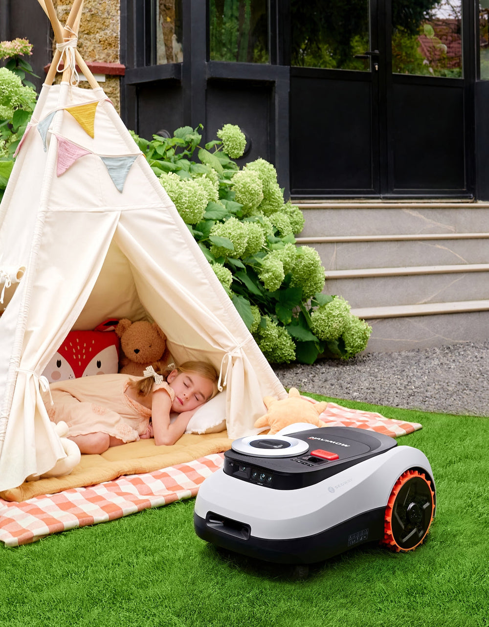 Segway Navimow i105E robot lawn mower near a sleeping girl.