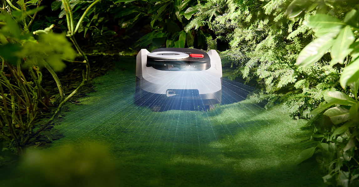 Navimow i110E robot lawn mower navigating through a green garden.