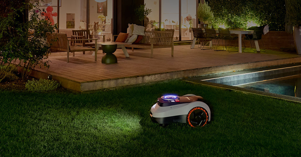 Navimow i110E robot lawn mower works on grass at night.