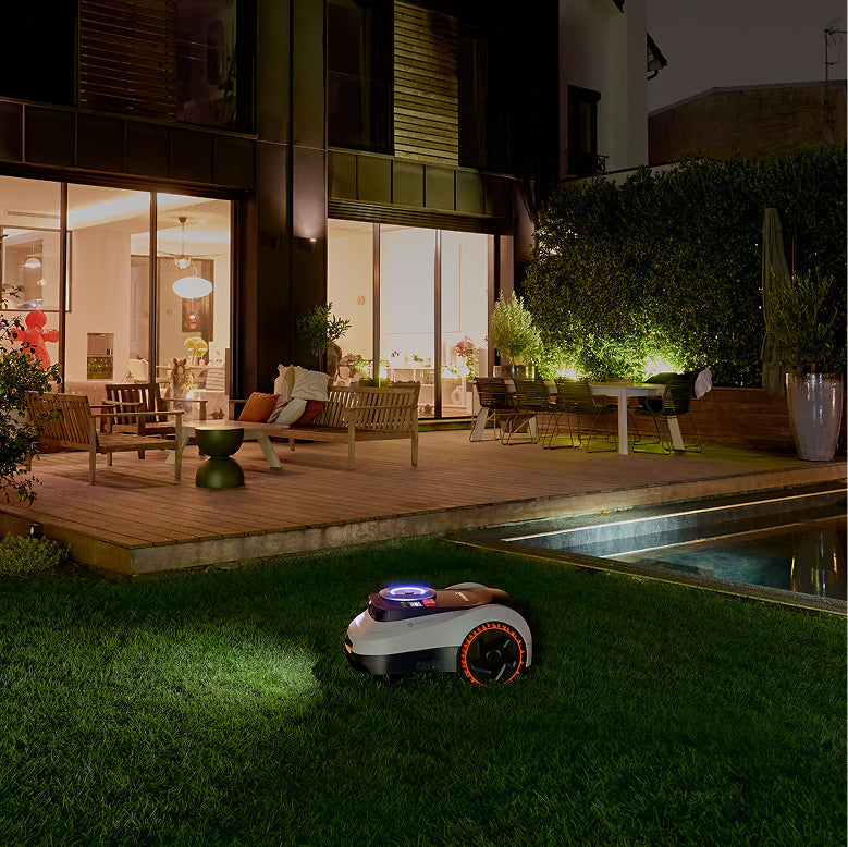 Navimow i110E robot lawn mower mows the grass at night.