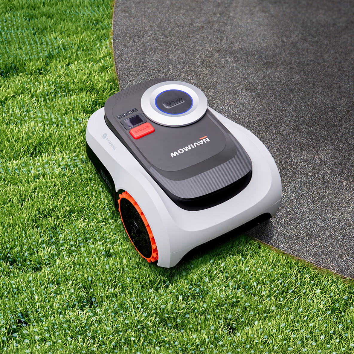 A Segway Navimow robot lawn mower on green garden grass.