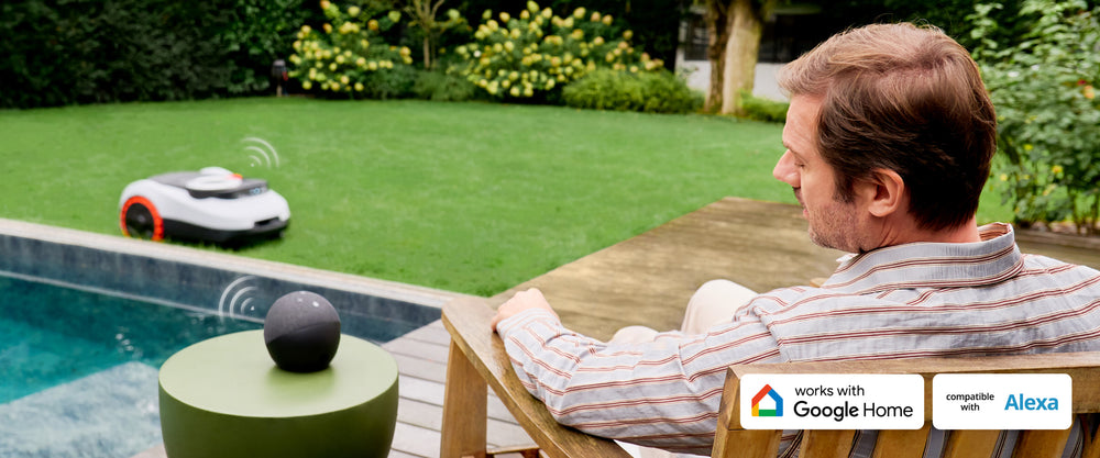 Navimow i110N robot lawn mower mows lawn as man relaxes.