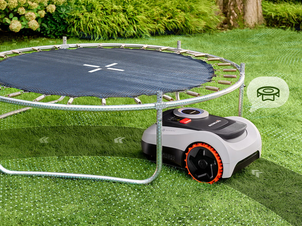 Segway Navimow i105E robot lawn mower mows grass under trampoline.