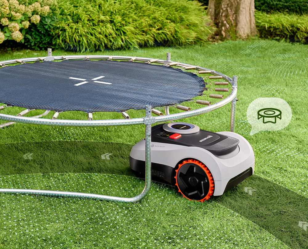 Segway Navimow i105E robot lawn mower mows grass under trampoline.